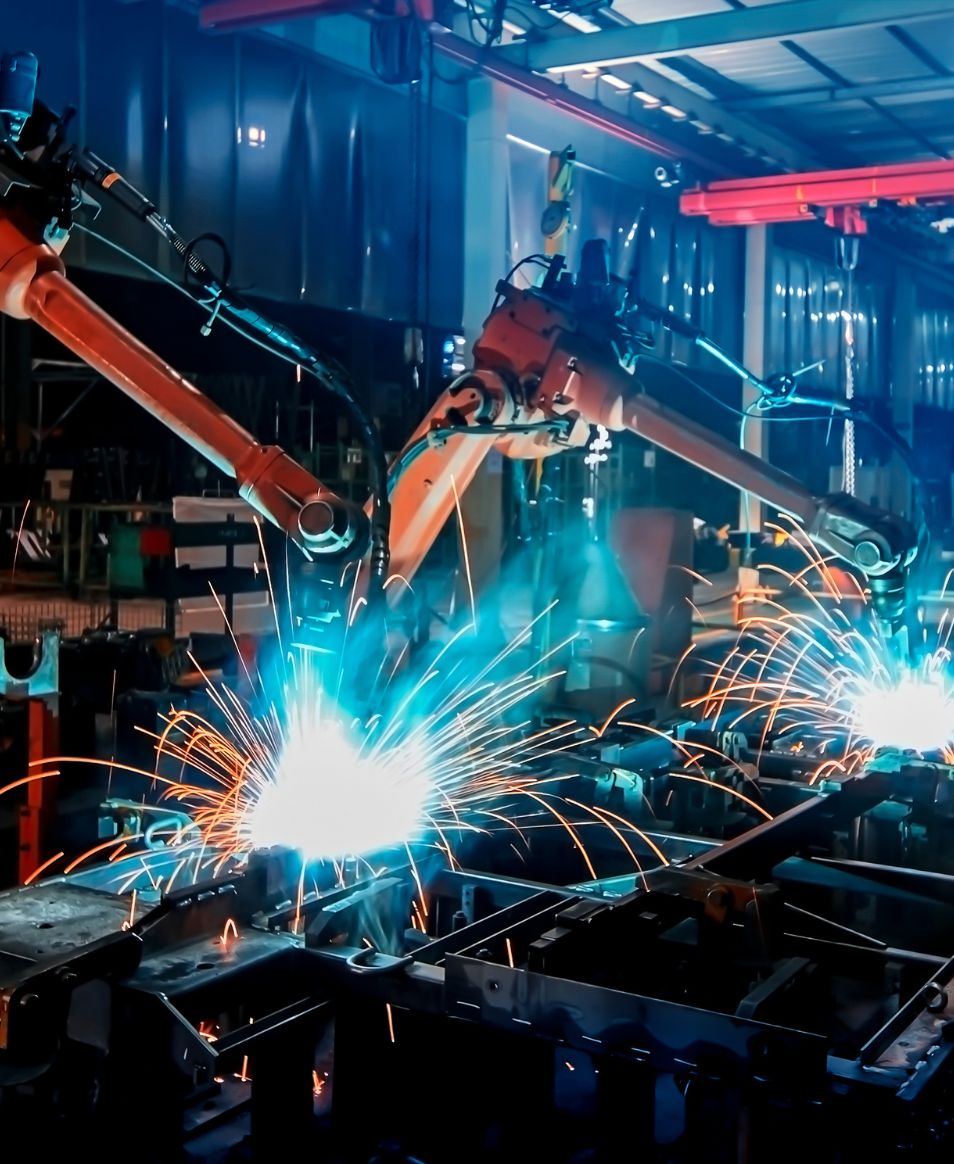 Robot spawalniczy wykonujący proces spawania w hali produkcyjnej